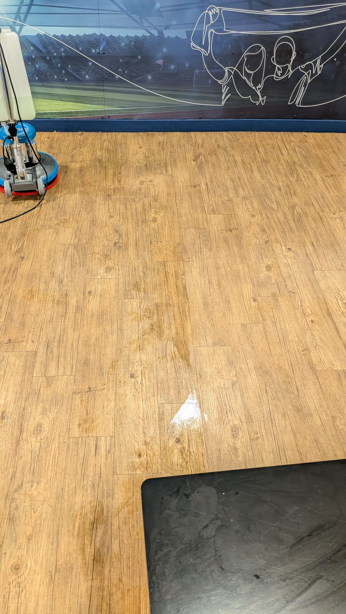 Wood-effect hard floor being cleaned with a rotary floor machine