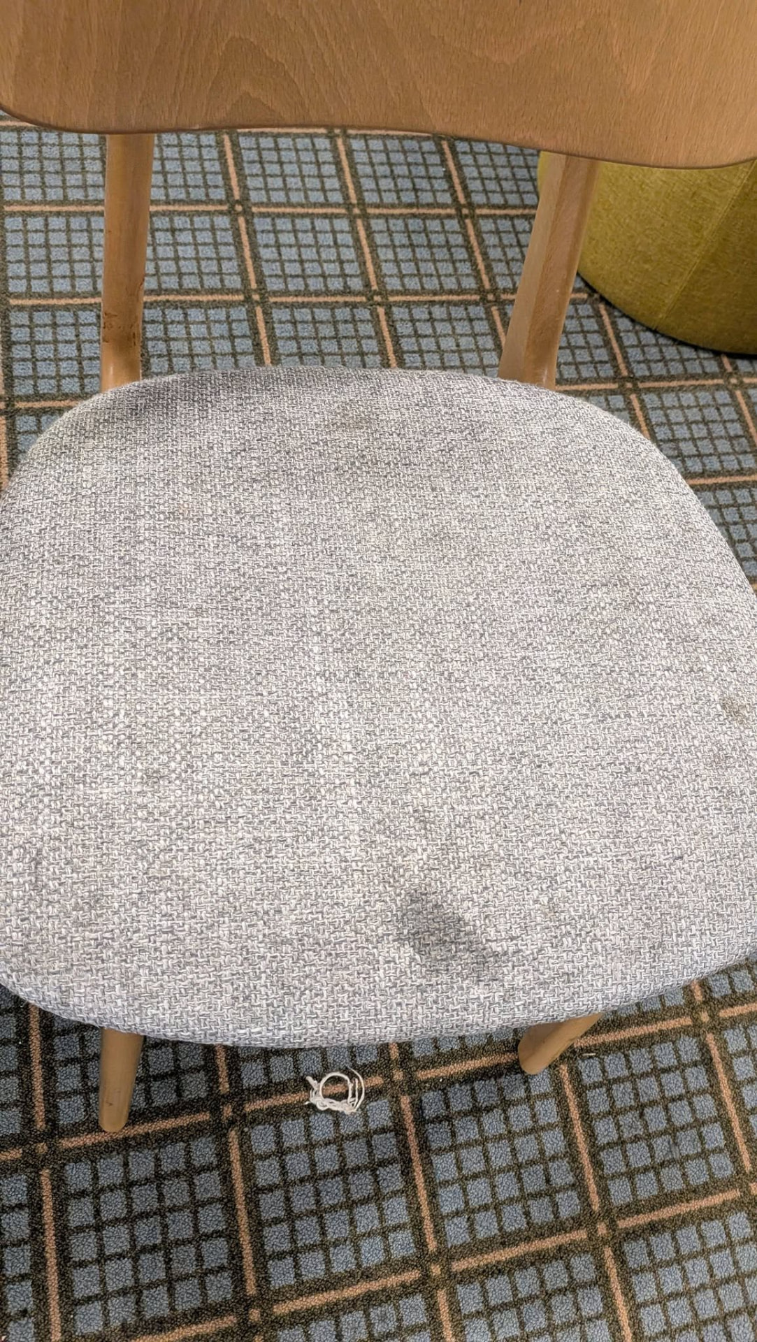 Grey upholstered wooden chair with marks before cleaning