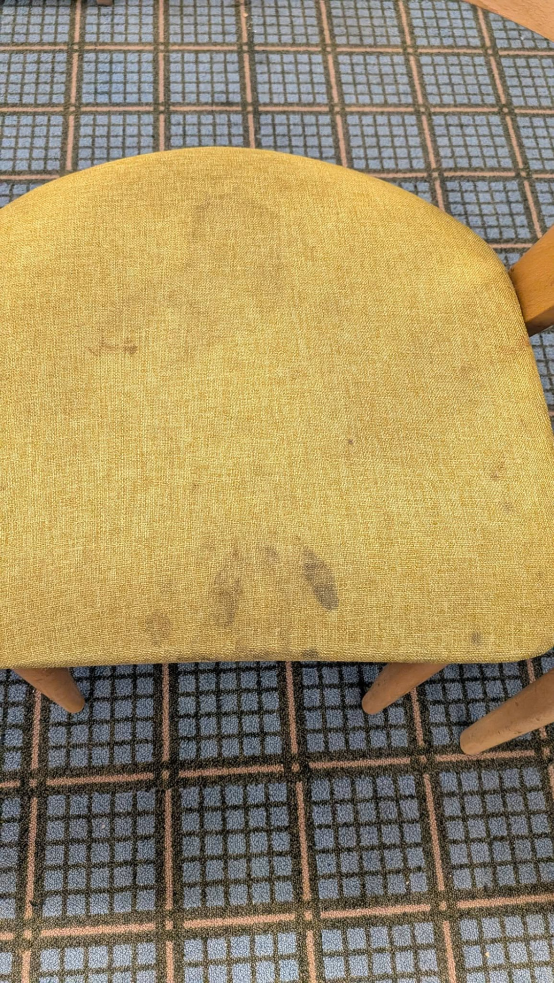 Yellow upholstered wooden chair with visible marks before cleaning